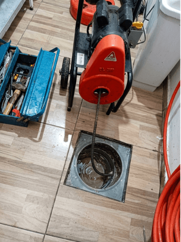 Equipamento profissional em serviço de desentupimento de ralo